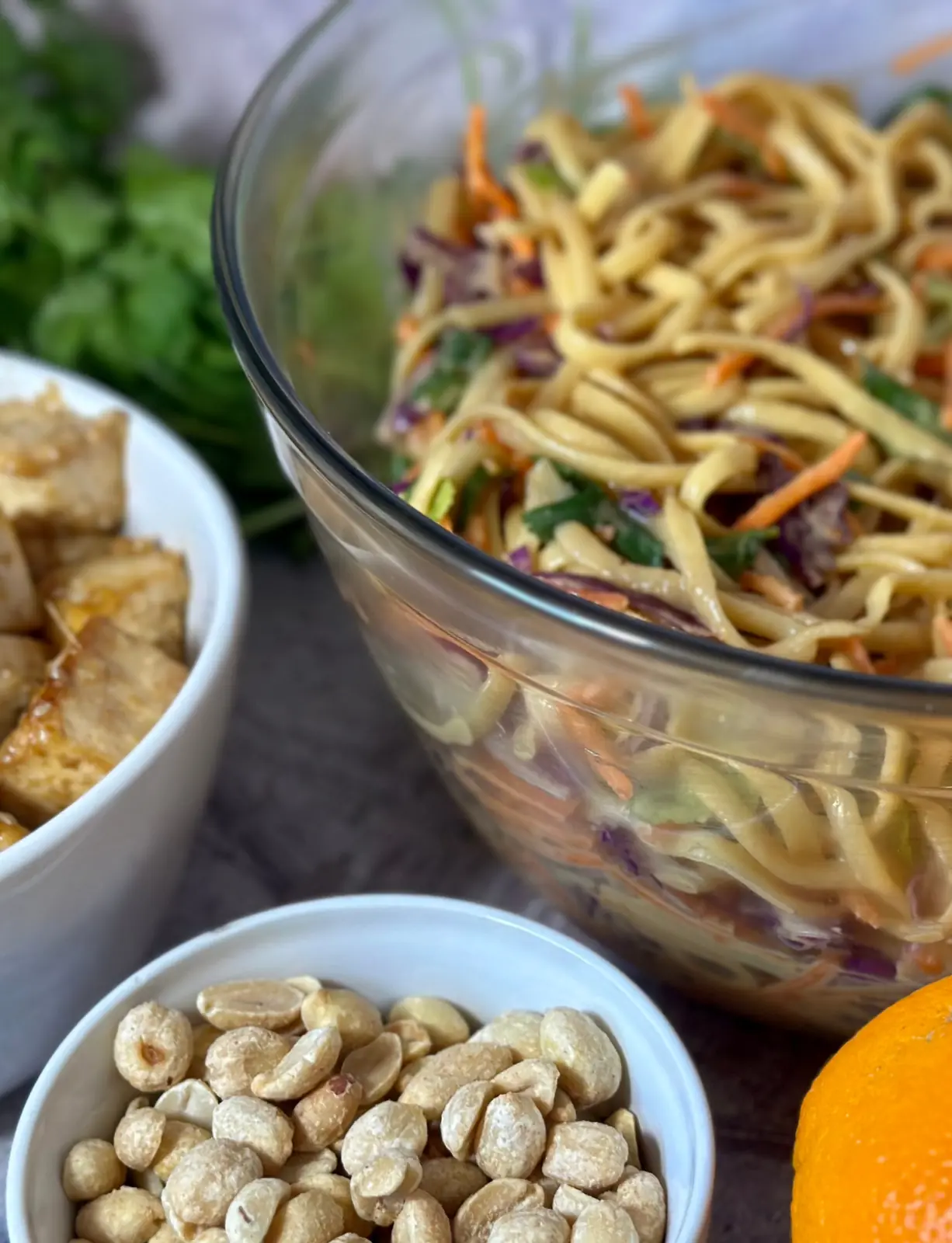 thai peanut noodle salad feature image up close glass bowl of noodles