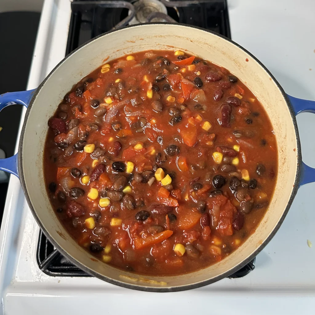 black bean chili with corn with 1 cup of corn mixed in on a white oven