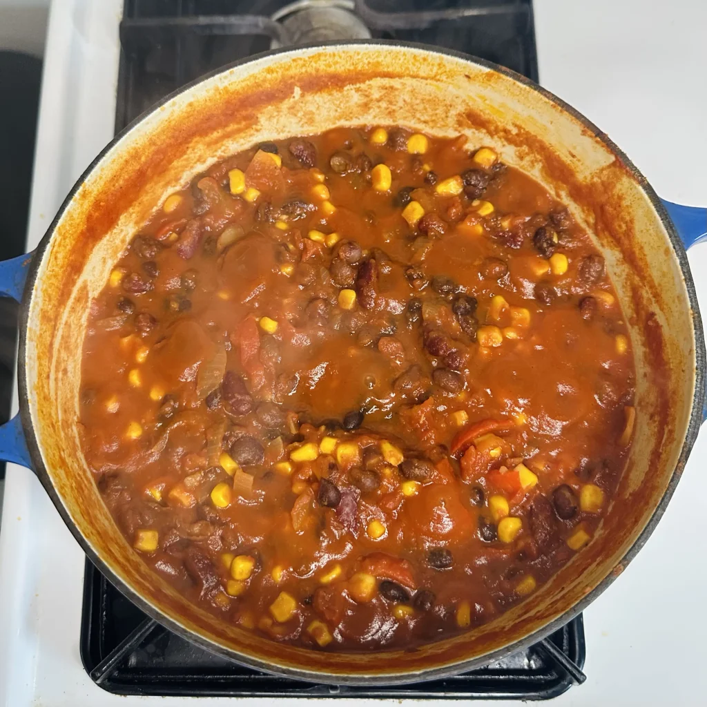 black bean chili with corn cooking in an uncovered pot 