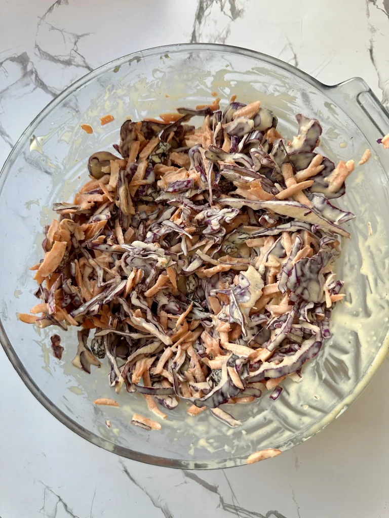 all ingredients for coleslaw mixed together in a bowl